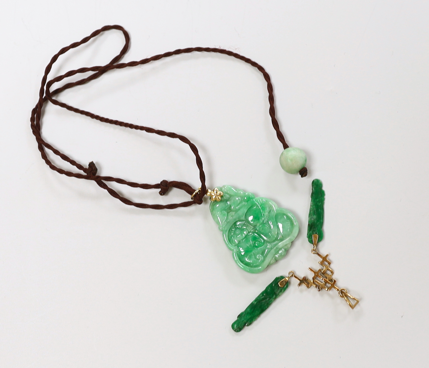 Two gold mounted jadeite pendants, largest 4.5cm long